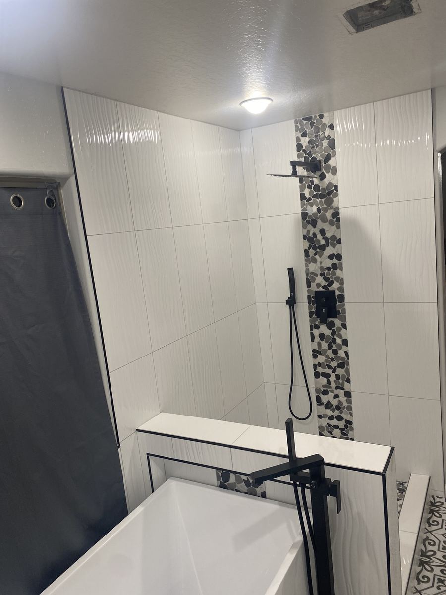 Tall white tile shower with a mosaic accent strip