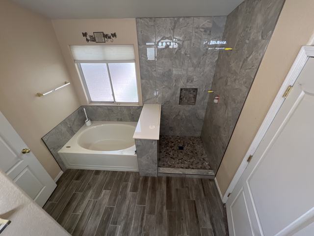 Soaking tub beside a tiled walk-in shower